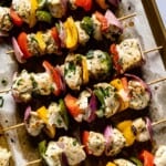 Oven baked chicken kabobs on a sheet pan from the top view.
