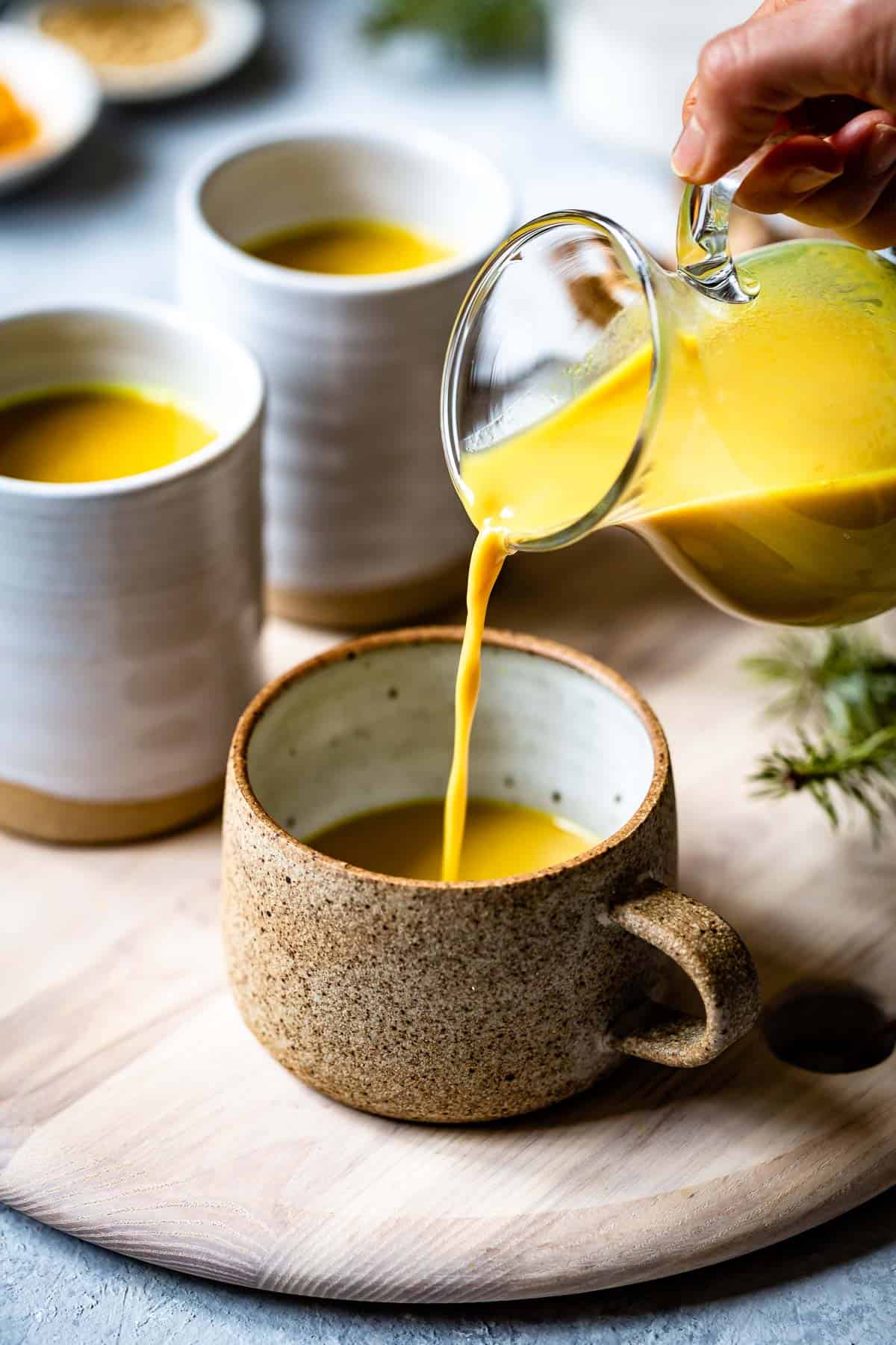 Golden Milk Tea being poured to a mug.